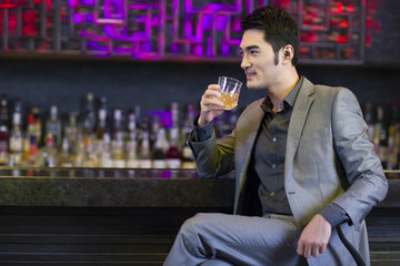 Young man having a drink at bar