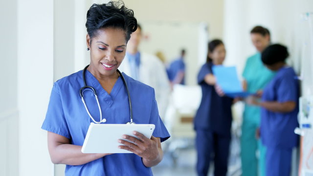 Portrait of African American female nurse working on technology in hospital