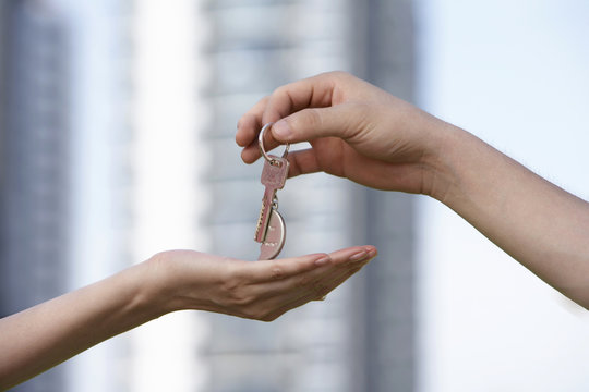 Hands Exchanging A Key