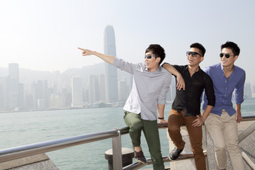 Fashionable young men enjoying the beautiful moment in Victoria Harbor, Hong Kong