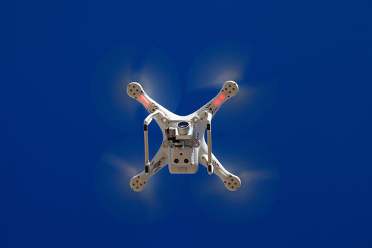 White drone equipped with high resolution 4K video camera with blue sky in the background