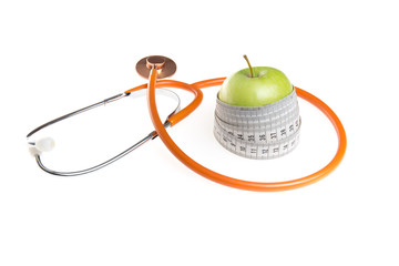 Green wet apple with yellow measuring tape and black stethoscope isolated on white background
