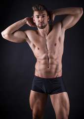 handsome young bodybuilder with toned body posing shirtless