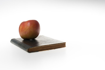 Red apple on a book isolated on white