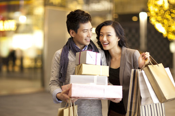 Happy young couple with gift boxes and shopping bags