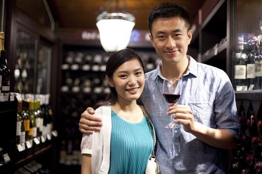 Young couple tasting wine in cellar
