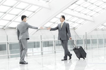 Business partners meeting in airport lobby