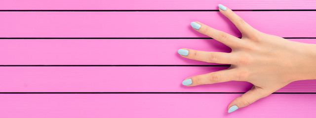 Female hand with blue nails over pink background - 99513678
