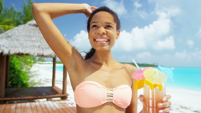 Beautiful African American girl with party cocktail drink on beach