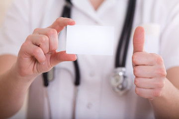 Female doctor showing business card and thumb up