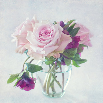 beautiful pink rose flowers in a vase on a vintage background.