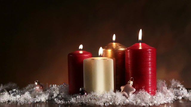 cinemagraph - four candles, three with flames still, and with a flame in perpetual motion
