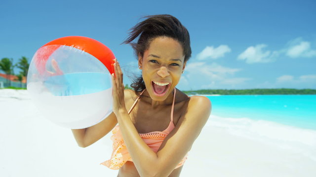 Ethnic African American female enjoying vacation with beach ball