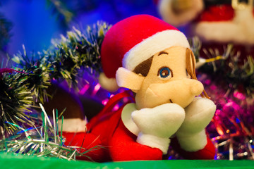 Magical elf lying under the tree, between Christmas toys
