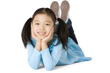 Young girl lying on stomach with legs in the air