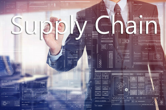 the businessman in the office is writing on the transparent board words associated with manufacturing: Supply Chain
