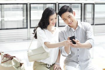 Obraz premium Young couple with mobile phone at subway station