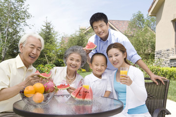 Three generation family eating watermelon