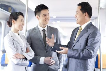 Business associates talking in subway train