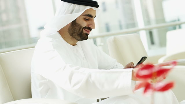 Arab business man kandura oil trade city touch screen technology smart phone