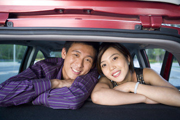 Young couple look out the back of their car