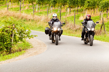 Zwei Motorradfahrer in einer idyllischen Landschaft