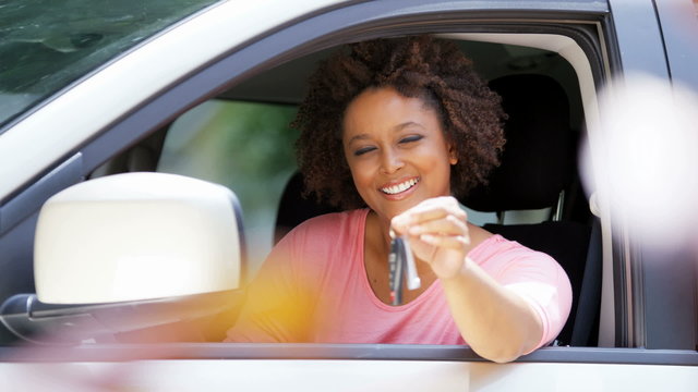 Portrait of young happy African American girl smiling holding car key in car