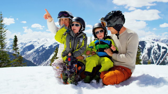 young Caucasian family parents sons outdoor snow ski recreation teamwork 