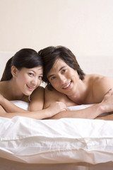 Asian couple close to each other on bed