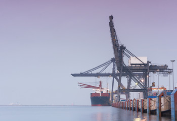 Fototapeta premium Containers loading by crane on morning dark