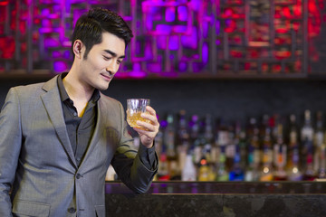 Young man having a drink at bar