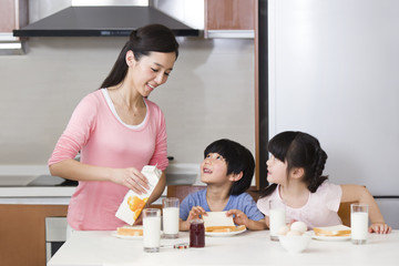 Mother pouring milk for children
