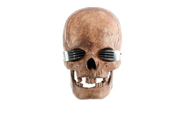 Skull with eyeglass by fork on white background