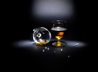 Two glasses of cognac
Two glasses of cognac, one of which overturned. Scattered necklace and a...