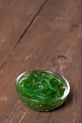 Chuka salad served in a small glass bowl on the old wooden table
