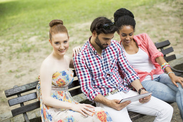 Friends on the bench with tablet