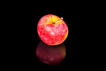 Fototapeta na wymiar Apples on black wavy mirror.