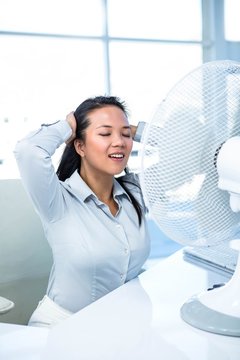 Businesswoman Sitting In Front Of Fan