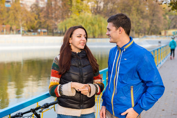 Young Couple Talking Together in Park in Autumn