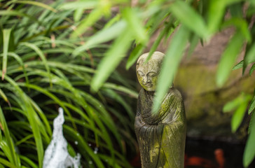 Meditation concept: monk statue in the pool. Vintage style 