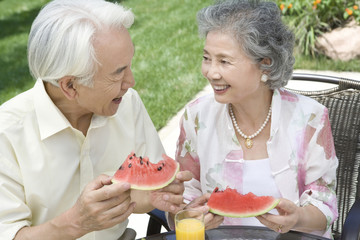 Senior couple eating watermelon