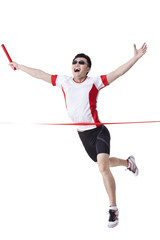 Male athlete with relay baton reaching the finish line