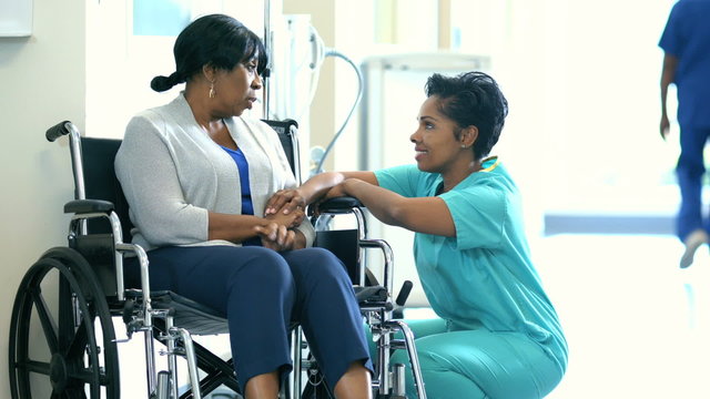 Medical consultation with African American female staff and disabled patient 