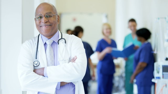 Portrait of confident African American male senior doctor in medical center
