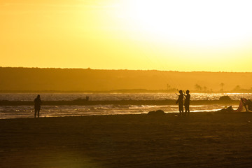 Silueta de personas al atardecer en la playa después de practicar kitesurf