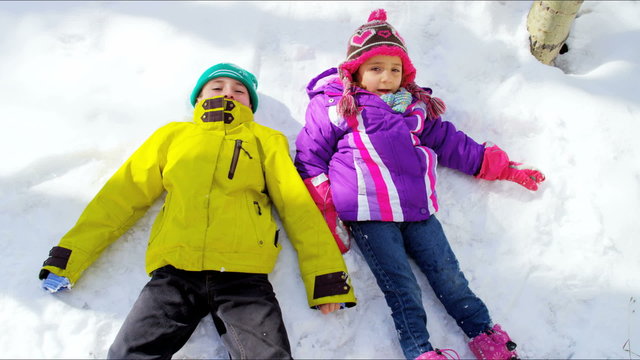 Caucasian young male female children play healthy outdoor active snow