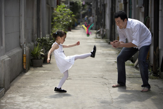 A father and daughter play a traditional game