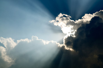 Sunbeam through the black stormy cloud