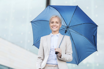 young smiling businesswoman with umbrella outdoors