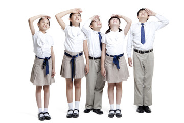 Schoolchildren looking up with hands shielding eyes from the sun